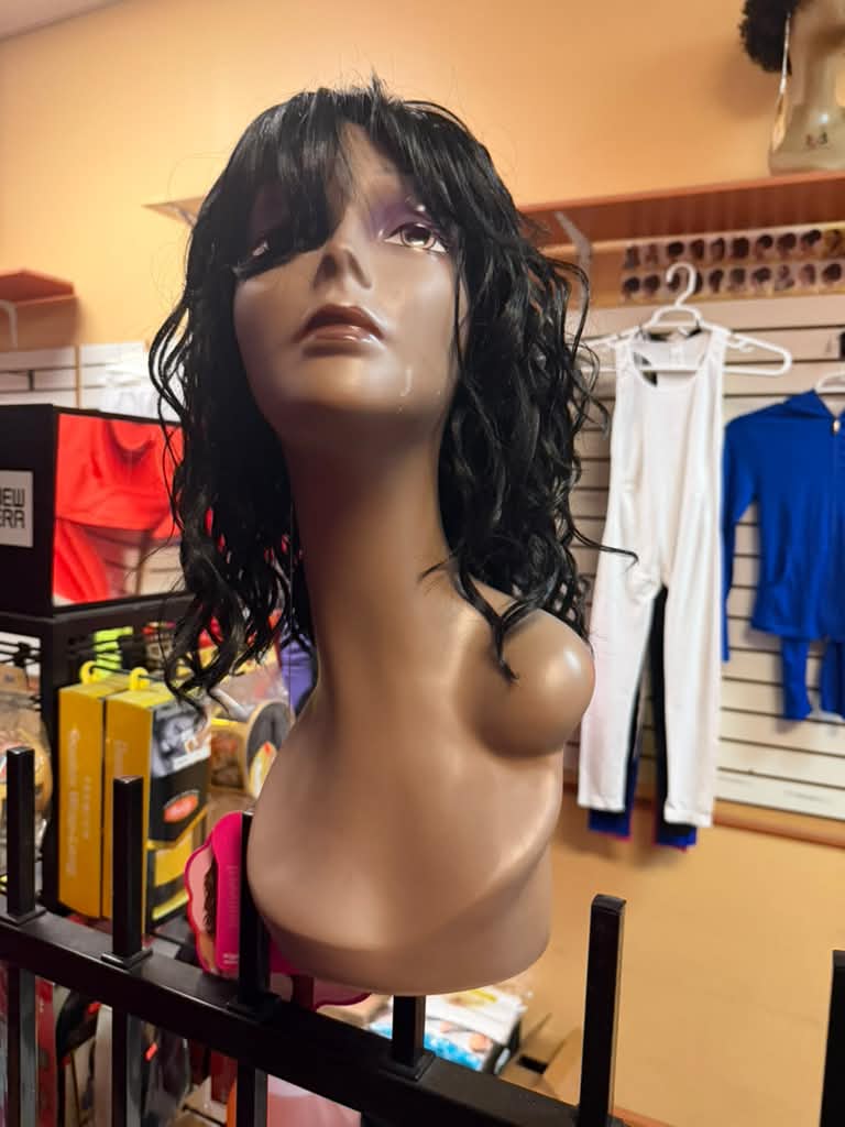 Medium-length black curly wig with bangs on a mannequin at Beyond Image Suites and Supplies in Cincinnati
