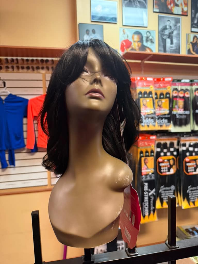 Medium-length black layered wig with bangs on a mannequin at Beyond Image Suites and Supplies in Cincinnati
