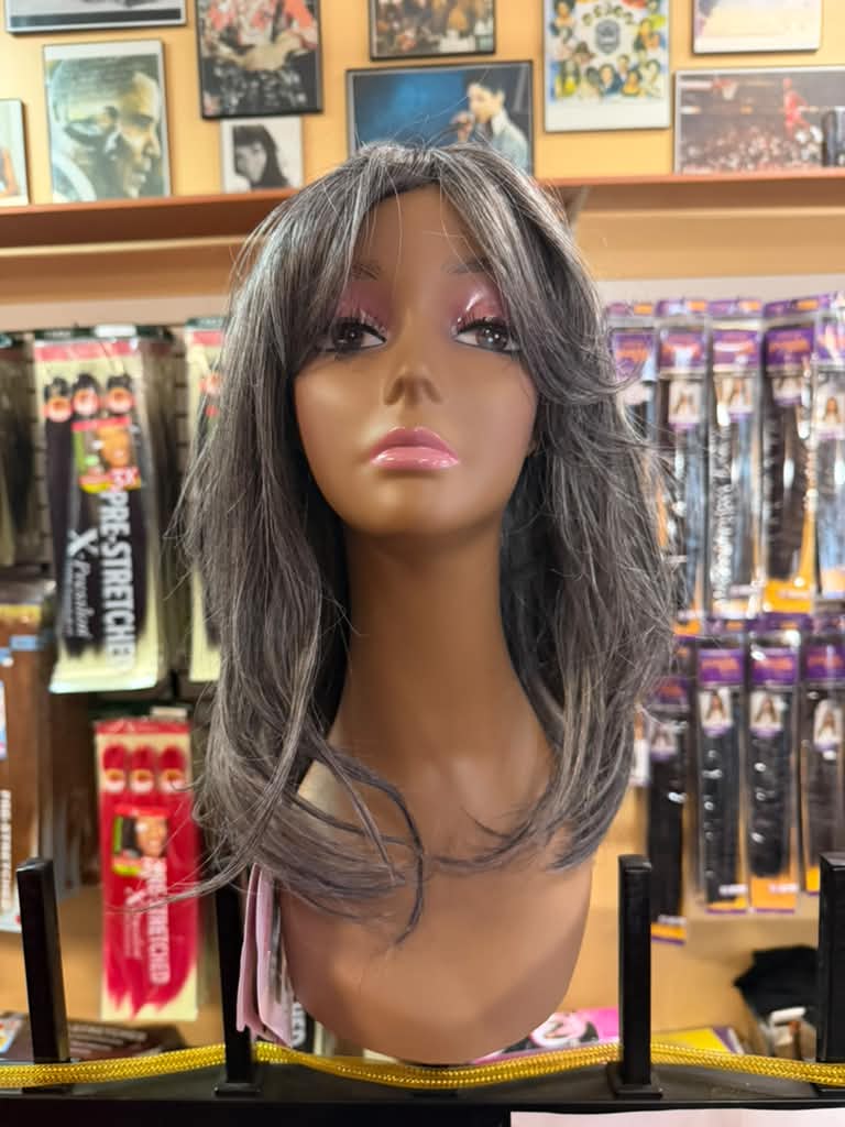 Medium-length gray salt-and-pepper layered wig with wispy bangs on a mannequin at Beyond Image Suites and Supplies