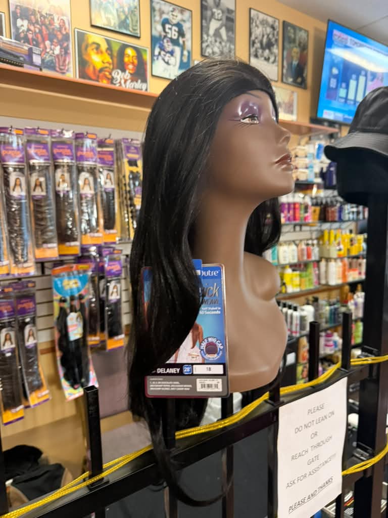 Side view of the Outre Quick Weave Delaney long straight black half wig displayed in store in Cincinnati