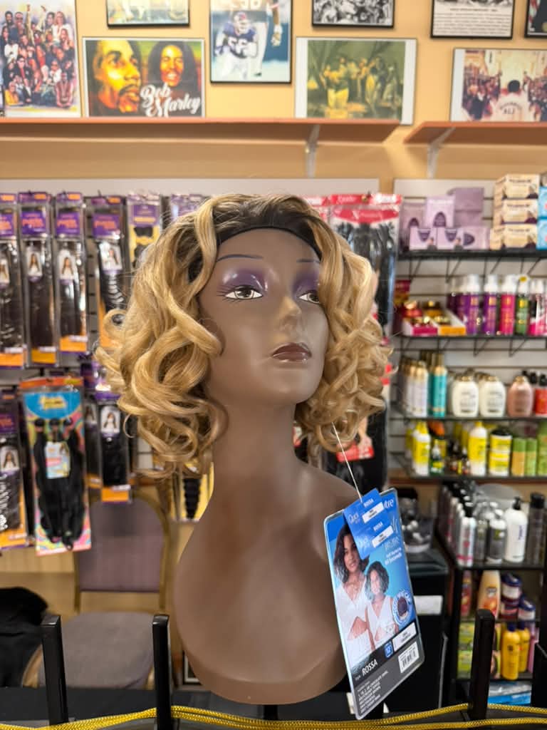 Outre Rossa short curly wig in honey blonde with dark ombre roots on a mannequin at Beyond Image Suites and Supplies