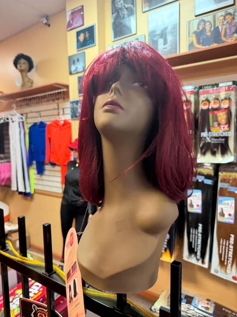 Front angle of a burgundy red Outre Wigpop bob wig with bangs at Beyond Image Suites and Supplies