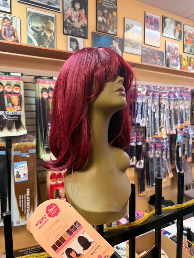 Outre Wigpop synthetic burgundy red bob wig with bangs on a mannequin at Beyond Image Suites and Supplies