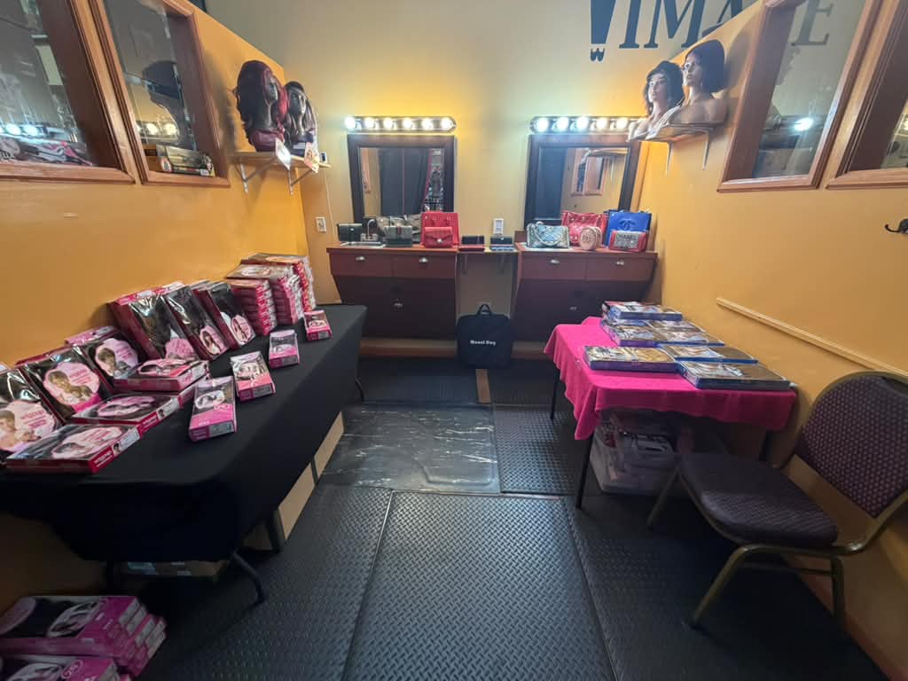 Wig fitting and styling area with lighted mirrors, boxed wigs and mannequin heads at Beyond Image Suites and Supplies