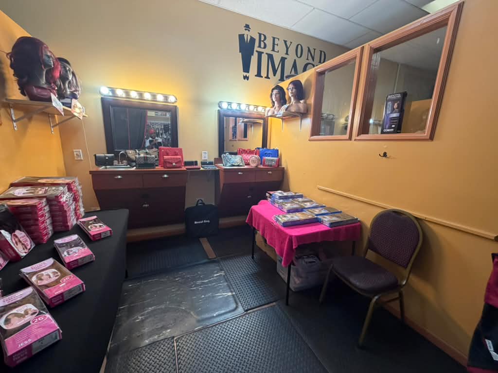 Wig try-on room with lighted vanity mirrors, wig boxes and Beyond Image logo at Beyond Image Suites and Supplies